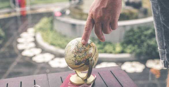 ręka trzymająca palec na globusie
