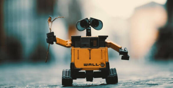 pomarańczowy robot trzymający w dłoni kawałek trawy